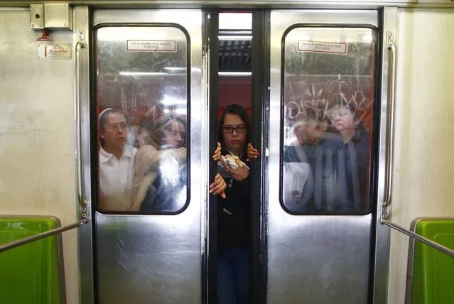 Passengers push open the sliding doors of a Women-Only passenger car in the subway in Mexico City October 24, 2014. Trains, buses and taxis for women only are on the rise in cities globally with a Thomson Reuters Foundation survey finding women feel safer on single-s*x transport but gender experts dismissing this as a band-aid solution that could backfire for women. (Photo by Edgard Garrido/Reuters)