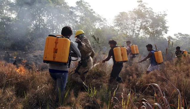 Firefighters and members of indigenous tribes attend a training at the Kamayura tribe, to combat wildfire in the Xingu National Park, Mato Grosso, Brazil, October 3, 2015. (Photo by Paulo Whitaker/Reuters)