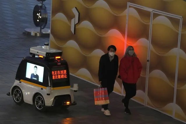 A police autonomous robot patrols a mall area in Beijing, Wednesday, December 28, 2022. China says it will resume issuing passports for tourism in another big step away from anti-virus controls that isolated the country for almost three years, setting up a potential flood of Chinese going abroad for next month's Lunar New Year holiday. (Photo by Ng Han Guan/AP Photo)