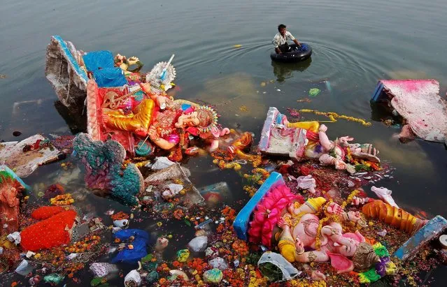 A man collects items thrown as offerings by worshippers into the Sabarmati river, a day after the immersion of idols of the Hindu god Ganesh, the deity of prosperity, in Ahmedabad, India September 16, 2016. (Photo by Amit Dave/Reuters)
