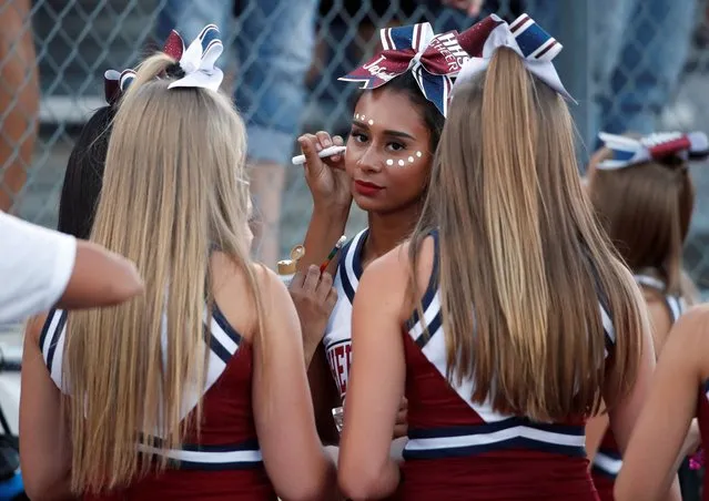 Herriman Mustangs cheerleaders put face paint on during a game against the Davis Darts, the first regular season football game in the United States since the coronavirus disease (COVID-19) pandemic began, at Herriman High School in Herriman, Utah, U.S. August 13, 2020. (Photo by George Frey/Reuters)