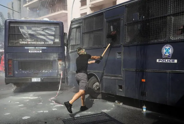 A protester hits a police vehicle during clashes outside a court, where the trial of leaders and members of the Golden Dawn far-right party takes place in Athens, Greece, October 7, 2020. (Photo by Costas Baltas/Reuters)