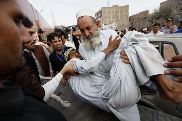 People carry a man who was injured in a 7.7 magnitude earthquake,  to a hospital in Peshawar, Pakistan, 26 October 2015. (Photo by Arshad Arbab/EPA)