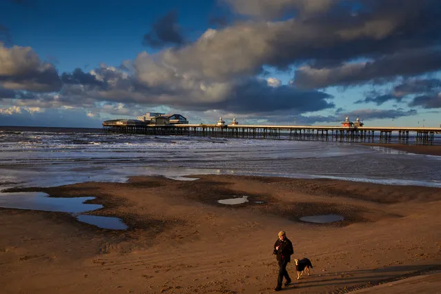 A dog walker at low tide in Blackpool, Rngland on December 28, 2017. (Photo by Christopher Thomond/The Guardian)