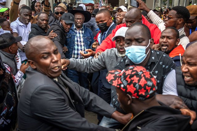 Former Kenyan Deputy President and opposition leader of the Democracy for the Citizens Party (DCP), Rigathi Gachagua (C), reacts as his security detail pushes back supporters welcoming him at Jomo Kenyatta International Airport in Nairobi on August 21, 2025. Violence erupted in Kenya's capital on August 21, 2025 with teargas and hired goons unleashed, as recently impeached former Deputy President Rigathi Gachagua returned from a month-long political tour in the United States. (Photo by Luis Tato/AFP Photo)