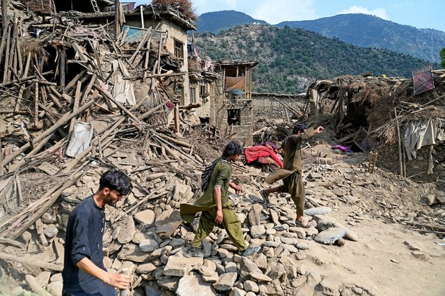 Afghans walk past damaged houses, after earthquakes at Mazar Dara village in Nurgal district, Kunar province, in Eastern Afghanistan, on September 1, 2025. (Photo by Wakil Kohsar/AFP Photo)