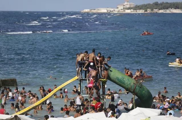 People crowd onto a slide at a public beach during a hot day in the Mediterranean city of Alexandria September 5, 2014. (Photo by Amr Abdallah Dalsh/Reuters)