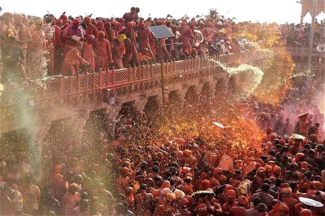 In this photograph taken on March 1, 2023, Hindu devotees celebrate Holi, the spring festival of colours, during a traditional gathering at a temple in Nandgaon village of India's Uttar Pradesh state. (Photo by AFP Photo/Stringer)