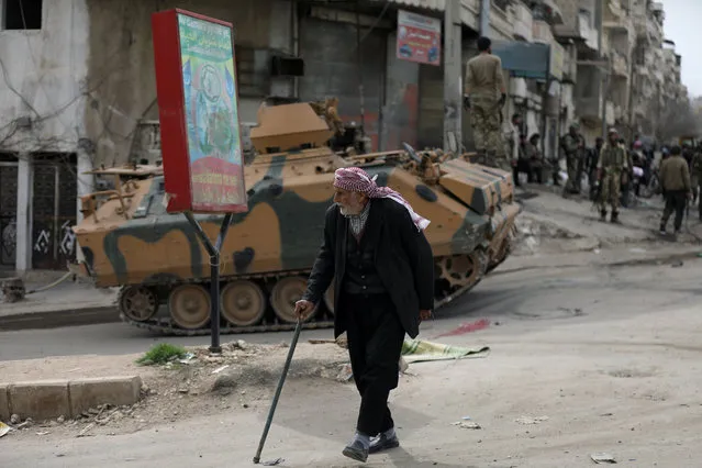 A Kurdish elderly man walks with a cane in Afrin, Syria on March 19, 2018. (Photo by Khalil Ashawi/Reuters)