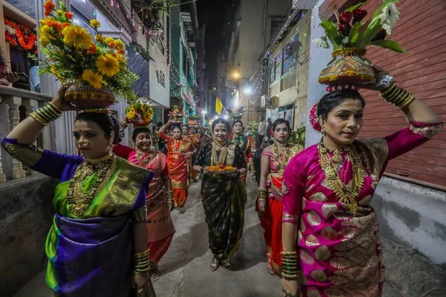 Indian women from the Koli community in traditional clothes take part in the procession to celebrate the “Holika Dahan” or burning of Holika on the eve of the Holi festival in Mumbai, India, 06 March 2023. Koli people indulge themselves into night long celebration with traditional procession, dances and folk songs. Holika is a demoness in Hindu mythology who was burned to death. The story of Holika's conflict signifies the triumph of good over evil, and the death of Holika is celebrated as Holi. (Photo by Divyakant Solanki/EPA)