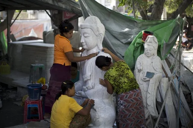 Women work on a Buddha sculpture near Mahamuni Buddhist temple in Mandalay October 6, 2015. (Photo by Jorge Silva/Reuters)