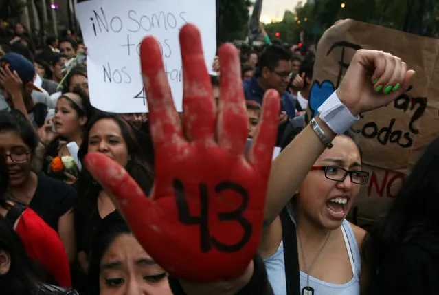 In this October 22, 2014 file photo, demonstrators protest the disappearance of 43 students from the Isidro Burgos rural teachers college, in Mexico City. Tens of thousands marched in Mexico City's main avenue demanding the return of the missing students who were rounded up by local police in Iguala, a town in southern Mexico, and handed over to gunmen from a drug cartel September 26. (Photo by Marco Ugarte/AP Photo)