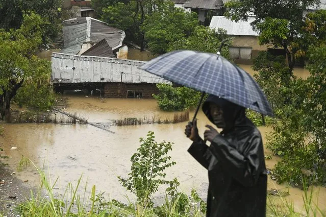 A man passes houses that are submerged in flood waters in Blantyre, Malawi Tuesday, March 14, 2023. The unrelenting Cyclone Freddy that is currently battering southern Africa has killed more than 50 people in Malawi and Mozambique since it struck the continent for a second time on Saturday night, (Photo by Thoko Chikondi/AP Photo)