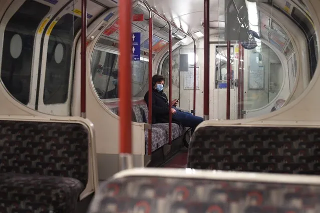 A man sits alone on a Bakerloo Line underground train in central London on December 20, 2020. Prime Minister Boris Johnson cancelled Christmas for almost 18 million people across London and eastern and south-east England following warnings from scientists of the rapid spread of the new variant coronavirus. (Photo by Victoria Jones/PA Images via Getty Images)