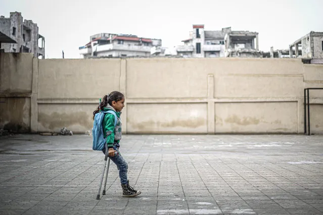 Syrian Fatima Ahmed al-Mustafa, who lost her left leg in an attack of Assad regime, walks with her crutches to her school in Idlib, Syria on November 21, 2020. Fatima, who moved with her family to a safer zone, close to the city center of Idlib, has to walk to school about 3 kilometers every day to continue her education. (Photo by Muhammed Said/Anadolu Agency via Getty Images)