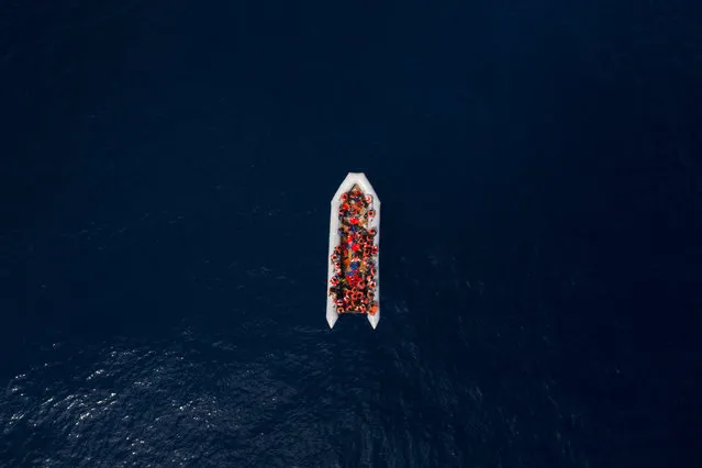 Refugees and migrants wait to be rescued by members of the Spanish NGO Proactiva Open Arms, after leaving Libya trying to reach European soil aboard an overcrowded rubber boat, north of Libyan coast, Sunday, May 6, 2018. In total 105 refugees and migrants from Bangladesh, Egypt, Nigeria, Marrocos, Gana, Pakistan, Sudan, Libya, Eritrea and Senegal were rescued in the overcrowded rubber boat. (Photo by Felipe Dana/AP Photo)
