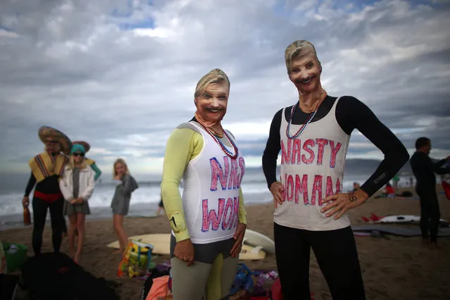 Daniela Burza, 45, (C) and Karen Stuhr, 46, (R) wear Nasty Woman t-shirts and masks of U.S. Democratic presidential nominee Hillary Clinton as they prepare to compete during the Haunted Heats Halloween Surf Contest in Santa Monica, California, U.S., October 29, 2016. (Photo by Lucy Nicholson/Reuters)