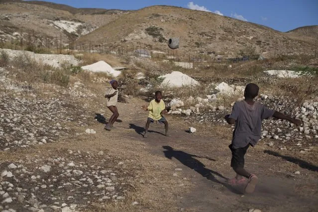 Children play soccer at a settlement on the arid hills north of the Capital in Port-au-Prince, Haiti, Friday, January 9, 2014. The area was initially only meant to house earthquake refugees stuck in tent shelters considered most at risk for floods or landslides, but it is growing so fast that U.S. State Department officials say the settlement could soon be considered Haiti’s second largest city. (Photo by Dieu Nalio Chery/AP Photo)