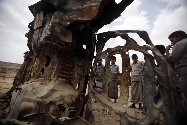 Boys gather near the wreckage of car destroyed last year by a U.S. drone air strike targeting suspected al Qaeda militants in Azan of the southeastern Yemeni province of Shabwa February 3, 2013. (Photo by Khaled Abdullah/Reuters)