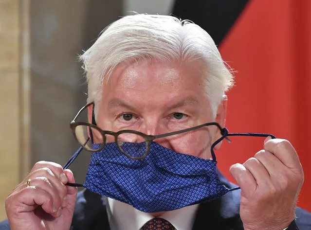 German President Frank-Walter Steinmeier struggles with his glasses and face mask as he attends a press conference after visiting the Salzburg Festival in Salzburg, Austria, Saturday, August 22, 2020. (Photo by Kerstin Joensson/AP Photo)