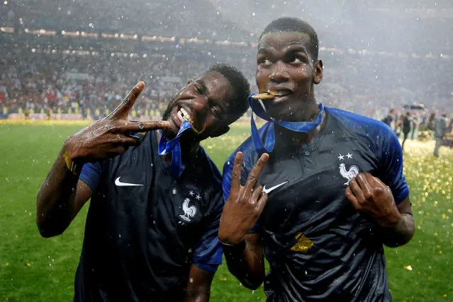 France' s midfielder Paul Pogba and France' s defender Samuel Umtiti celebrate with their medals after the Russia 2018 World Cup final football match between France and Croatia at the Luzhniki Stadium in Moscow on July 15, 2018. (Photo by Carl Recine/Reuters)