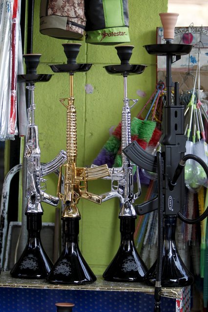 Hookahs shaped like rifles are displayed for sale in a souk at the port city of Sidon, southern Lebanon, December 23, 2015. (Photo by Ali Hashisho/Reuters)
