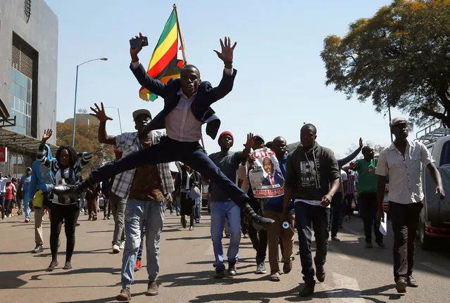 Supporters of the opposition Movement for Democratic Change (MDC) party of Nelson Chamisa, sing and dance as they march in the streets of Harare, Zimbabwe, August 1, 2018. (Photo by Siphiwe Sibeko/Reuters)
