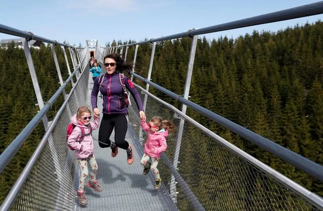 Visitors enjoy a walk accross a suspension bridge for the pedestrians that is the longest such construction in the world shortly after its official opening at a mountain resort in Dolni Morava, Czech Republic, Friday, May 13, 2022. The 721-meter (2,365 feet) long bridge is built at the altitude of more than 1,100 meters above the sea level. It connects two ridges of the mountains up to 95 meters above a valley between them. (Photo by David W. Cerny/Reuters)