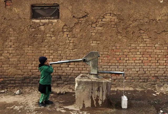 A girl collects drinking water for her family at a slum on the outskirts of Islamabad February 6, 2015. (Photo by Faisal Mahmood/Reuters)