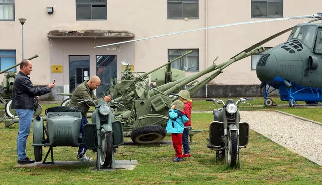 Children pose for photogrpahs near old outdated weaponry of the Albanian army which are on show at the Defense Ministry in the capital Tirana, Monday November 28, 2016, for the celebrations of Independence Day. (Photo by Hektor Pustina/AP Photo)