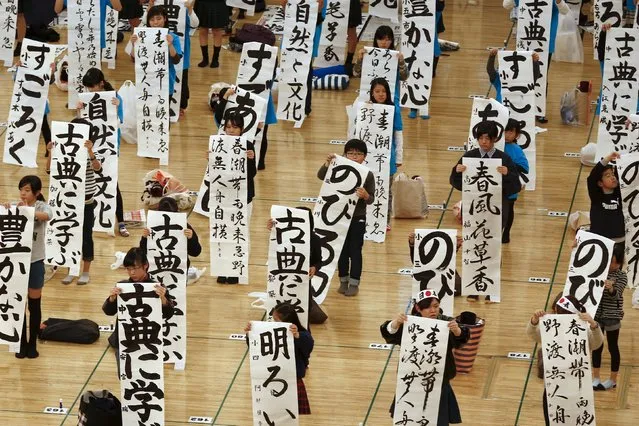 Pupils hold sheets with kanji characters they wrote during a calligraphy contest to celebrate the New Year in Tokyo January 5, 2016. (Photo by Thomas Peter/Reuters)