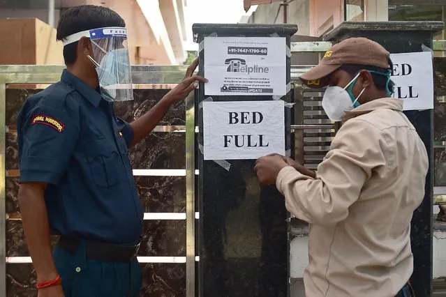 A security guard puts up a notice informing the non-availability of beds for patients in a private hospital amid Covid-19 coronavirus pandemic in Allahabad on April 22, 2021. (Photo by Sanjay Kanojia/AFP Photo)