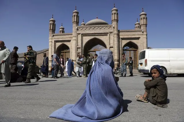 An Afghan woman waits for alms during the first day of Eid al-Fitr in Kabul, Afghanistan, Thursday, May 13, 2021. Eid al-Fitr prayer marks the end of the holy fasting month of Ramadan in Afghanistan. (Photo by Rahmat Gul/AP Photo)