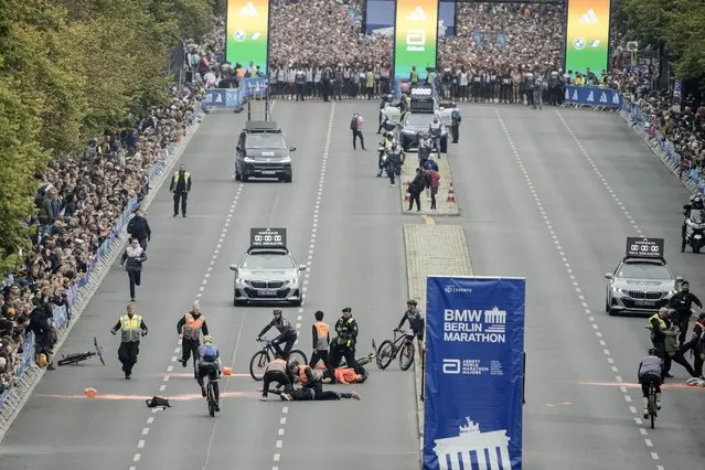 Police remove activists from the track before the start of the Berlin Marathon in Berlin, Germany, Sunday, September 24, 2023. Activists of the “Last Generation”, Letzte Generation, block the track of the Berlin Marathon to protest against the climate policies of the German government. (Photo by Markus Schreiber/AP Photo)