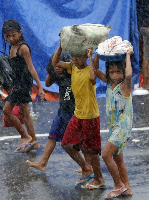 Survivors carry their belongings amidst heavy downpour after Typhoon Haiyan battered Tacloban city in central Philippines November 10, 2013. (Photo by Erik De Castro/Reuters)