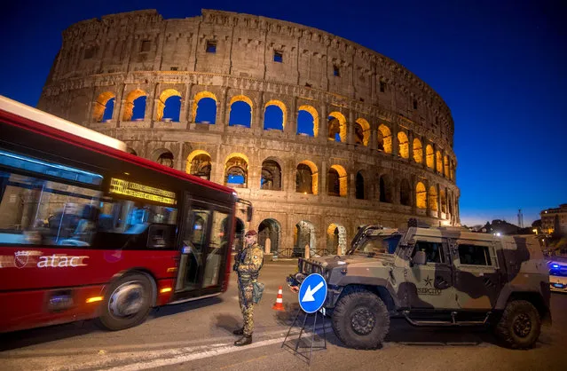 A bus passes by an Italian soldier patrolling the area of the ancient Colosseum in Rome, Wednesday, December 28, 2016. Italy has been strengthening security measures for areas where crowds are expected. (Photo by Claudio Peri/ANSA via AP Photo)