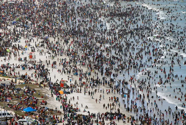 Crowds of revellers enjoy New Year's Day on a beach at Muizenberg in Cape Town, South Africa January 1, 2017. (Photo by Mike Hutchings/Reuters)