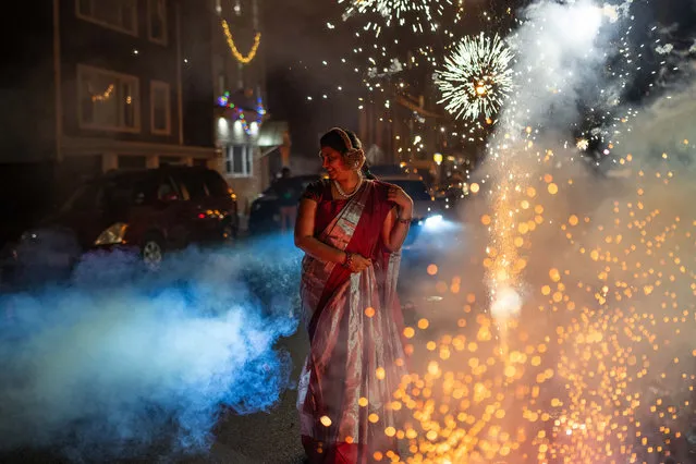 A woman stands amidst fireworks as they celebrate Diwali on November 12, 2023 in Jersey City, New Jersey. Diwali, also known as Deepavali, or the “festival of lights”, is a popular Hindu festival that symbolizes the spiritual “victory of light over darkness, good over evil, and knowledge over ignorance”. (Photo by Adam Gray/Getty Images)