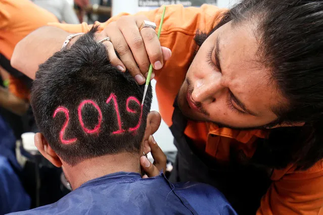 A man applies colour to a haircut with the number “2019”, depicted to welcome the new year at a barbershop in Ahmedabad, India, December 30, 2018. (Photo by Amit Dave/Reuters)