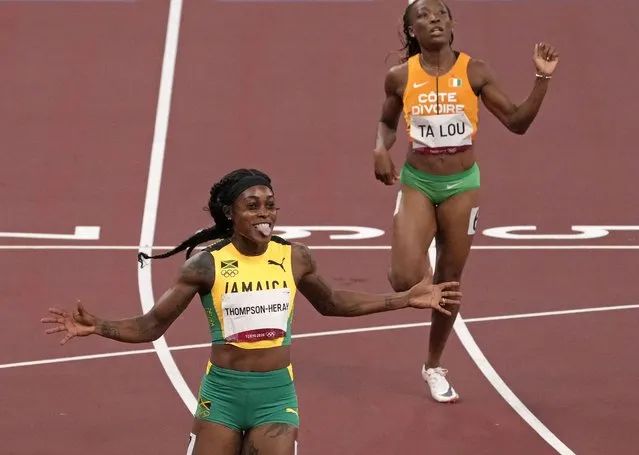 Elaine Thompson-Herah, of Jamaica celebrates after winning the gold medal in the final of the women's 200-meter at the 2020 Summer Olympics, Tuesday, August 3, 2021, in Tokyo, Japan. (Photo by Charlie Riedel/AP Photo)