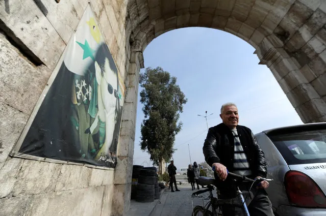 A man pushes a bicycle past a picture of Syria's President Bashar al-Assad at Bab Sharqi entrance, near the Jobar district of Damascus, Syria, January 5, 2017. (Photo by Omar Sanadiki/Reuters)