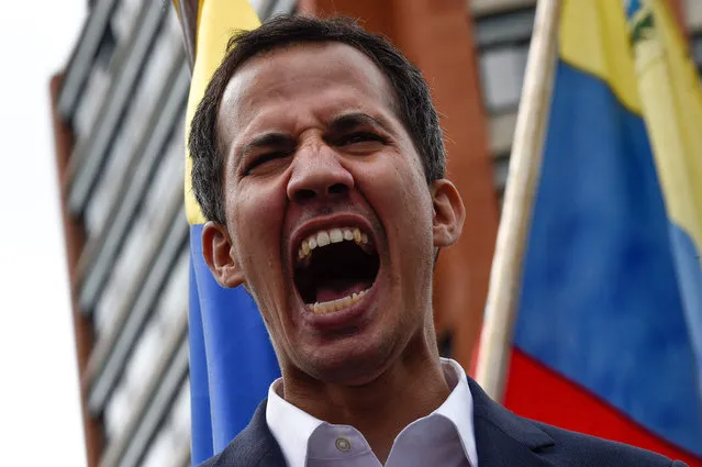 Venezuela's National Assembly head Juan Guaido shouts as he speaks to the crowd during a mass opposition rally against leader Nicolas Maduro in which he declared himself the country's “acting president”, on the anniversary of a 1958 uprising that overthrew a military dictatorship, in Caracas on January 23, 2019. “I swear to formally assume the national executive powers as acting president of Venezuela to end the usurpation, (install) a transitional government and hold free elections”, said Guaido as thousands of supporters cheered. Moments earlier, the loyalist-dominated Supreme Court ordered a criminal investigation of the opposition-controlled legislature. (Photo by Federico Parra/AFP Photo)