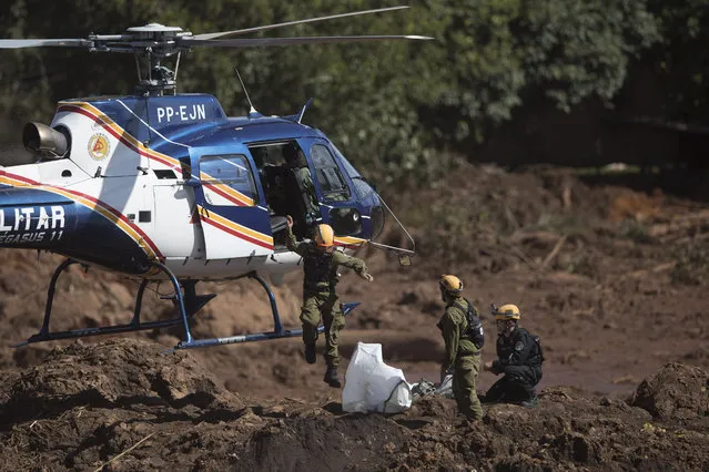 Israeli rescue specialists arrive at a site where a body was found inside a vehicle stuck in the mud, days after a dam collapse in Brumadinho, Brazil, Monday, January 28, 2019. (Photo by Leo Correa/AP Photo)