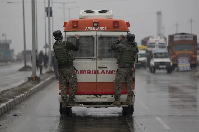 Indian paramilitary soldiers hang on to an ambulance carrying bodies of their colleagues near the site of an explosion in Pampore, Indian-controlled Kashmir, Thursday, February 14, 2019. Security officials say at least 10 soldiers have been killed and 20 others wounded by a large explosion that struck a paramilitary convoy on a key highway on the outskirts of the disputed region's main city of Srinagar. (Photo by Dar Yasin/AP Photo)