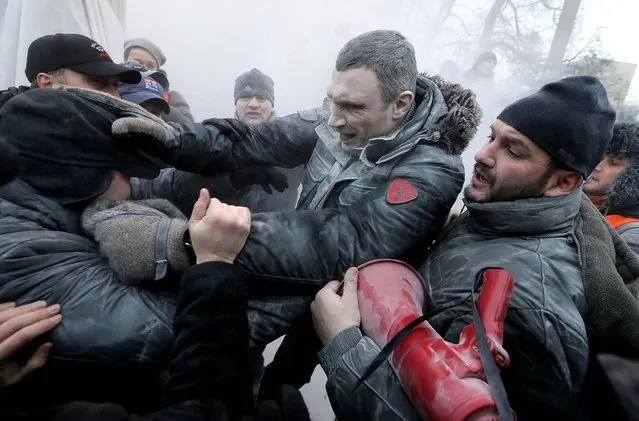 Opposition leader and former WBC heavyweight boxing champion Vitali Klitschko, center, is attacked and sprayed with a fire extinguisher as he tries to stop clashes between police and protesters  in Kiev, Ukraine, on January 19, 2014.(Photo by Efrem Lukatsky/Associated Press)
