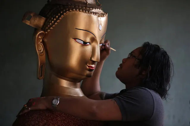 Saroj Shakya, 26, gives a finishing touch to an idol of Buddha ahead of the Samyak festival in Lalitpur, Nepal, March 11, 2016. (Photo by Navesh Chitrakar/Reuters)