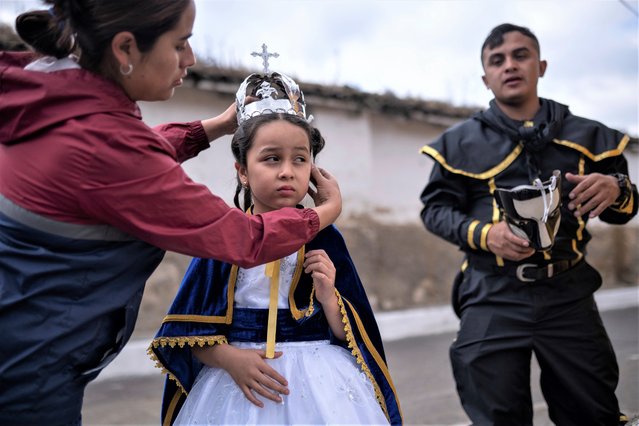 Viviana Vega places a crown on her seven-year-old daughter Valerie who is dressed as the Virgin of the Immaculate Conception during the annual tradition “La quema del diablo”, or burning of the devil, that coincides with the Immaculate Conception celebrations in Antigua, Guatemala, Wednesday, December 7, 2022. The Old City holds their town's days-long annual festival in honor of their patron saint, the Virgin of the Immaculate Conception and her triumph over evil. (Photo by Santiago Billy/AP Photo)