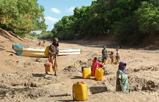 People collect water from shallow wells dug along the Shabelle River bed, which is dry due to drought in Somalia's Shabelle region, March 19, 2016. (Photo by Feisal Omar/Reuters)