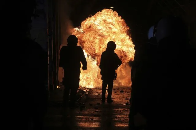 A petrol bomb explodes in from of riot police during clashes in the Athens neighborhood of Exarchia, a haven for extreme leftists and anarchists, Thursday, December 6, 2018. New protest marches were underway in Greece Thursday evening on the 10th anniversary of the fatal police shooting of a teenager, hours after violent initial demonstrations where masked youths attacked police with firebombs and stones. (Photo by Yorgos Karahalis/AP Photo)