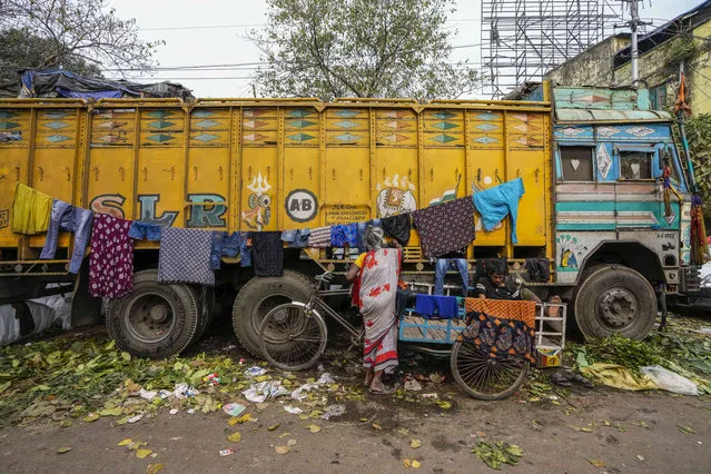 A woman hangs wet clothes to dry on a parked truck in Kolkata, India, Thursday, ebruary 22, 2024. (Photo by Bikas Das/AP Photo)